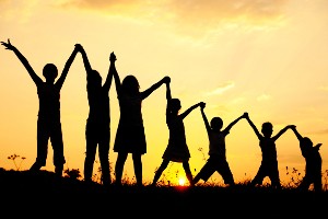 kozzi-silhouette_group_of_happy_children_playing_on_meadow_sunset_summertime-2389x1590